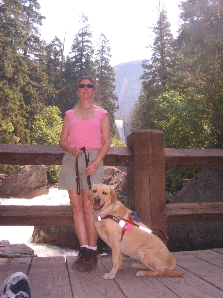 Janice standing with her guide dog, Liza, overlooking Vernal Falls, Yosemite.
